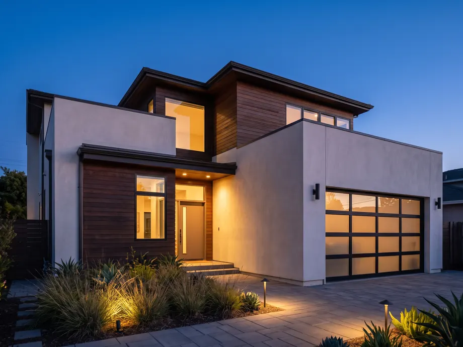 Two-storey Shape home at dusk with warm interior light